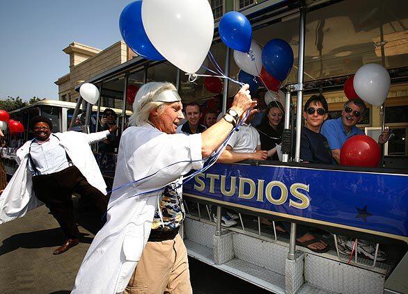 Movie character look-alikes, Doc Brown, right, and the Nutty Professor hand out balloons to visitors on the trams during the celebration as Universal Studios reopens Courthouse Square after a year of rebuilding the famous movie set.