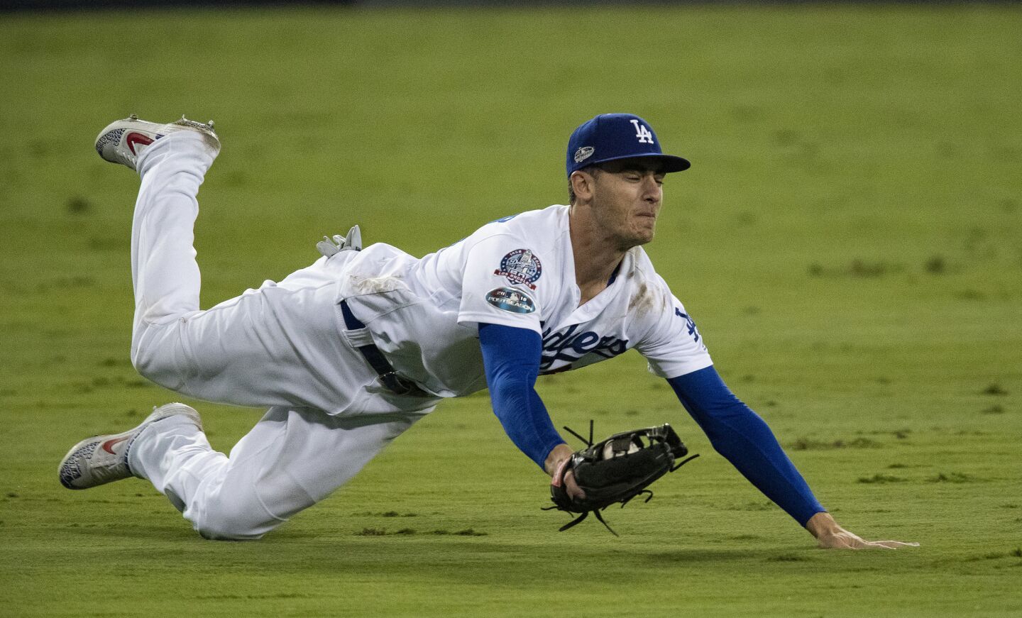 Dodgers center fielder Cody Bellinger makes a diving catch on a hit by Brewers center fielder Lorenzo Cain in the ninth inning.