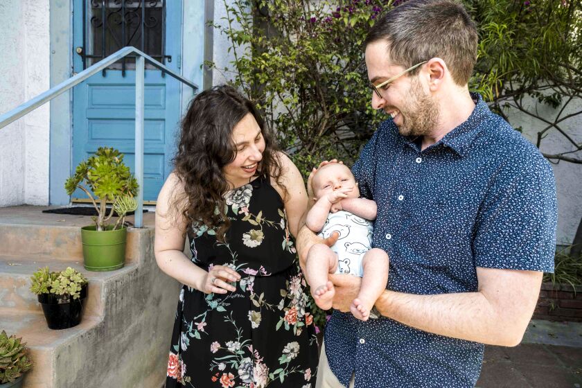 LOS ANGELES, CA - FRIDAY, APRIL 01, 2022 - (L-R) Nadine Levyfield (mom), baby Lev Marshak and Charlie Marshak (dad). ADU in Eagle Rock is a very simple garage conversion with two bedrooms, one bathroom, a full kitchen and living room that they built in 2018-19 for $300,000. Nadine Levyfield's mother, Mona Field, built the ADU for the young family, and eventually, they are going to switch homes: Field is going to move into the 800 square foot ADU, and the family is going to move into Levyfield's childhood home. Ricardo DeAratanha / Los Angeles Times.