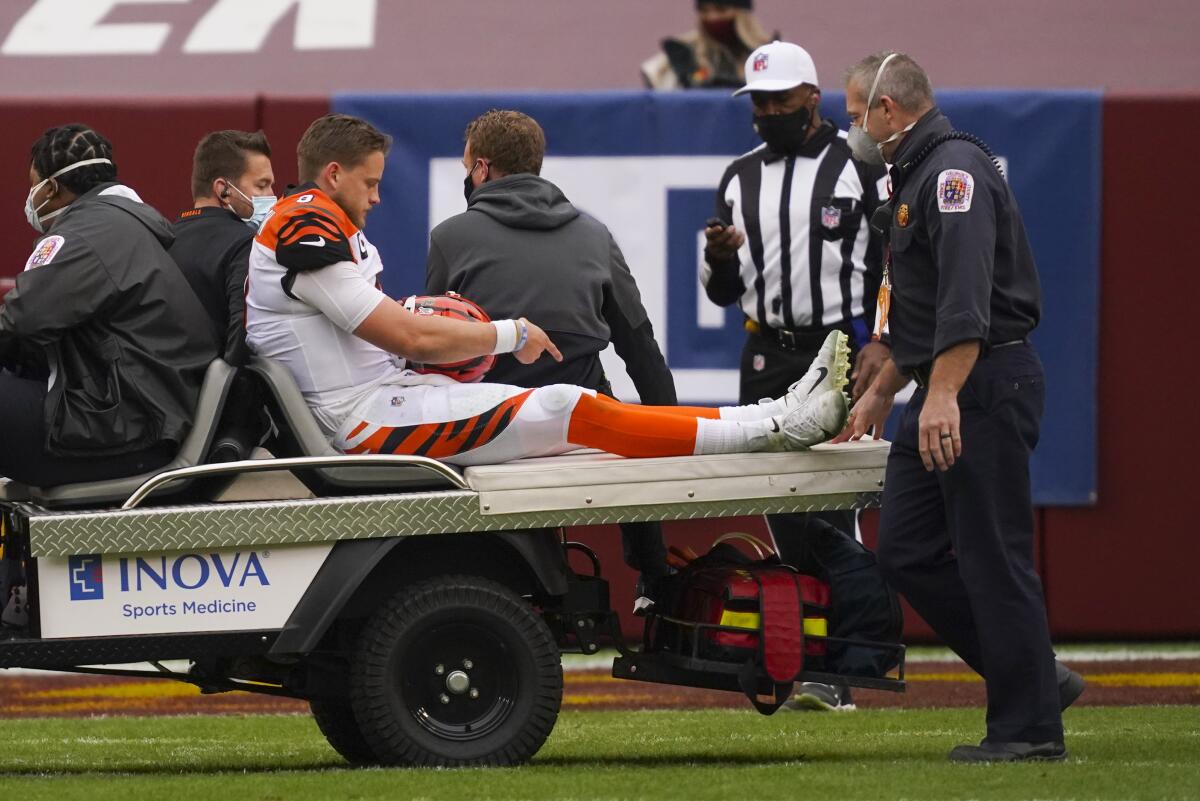 Bengals quarterback Joe Burrow (9) points to his injured knee as he is transported from the field on Nov. 22, 2020.