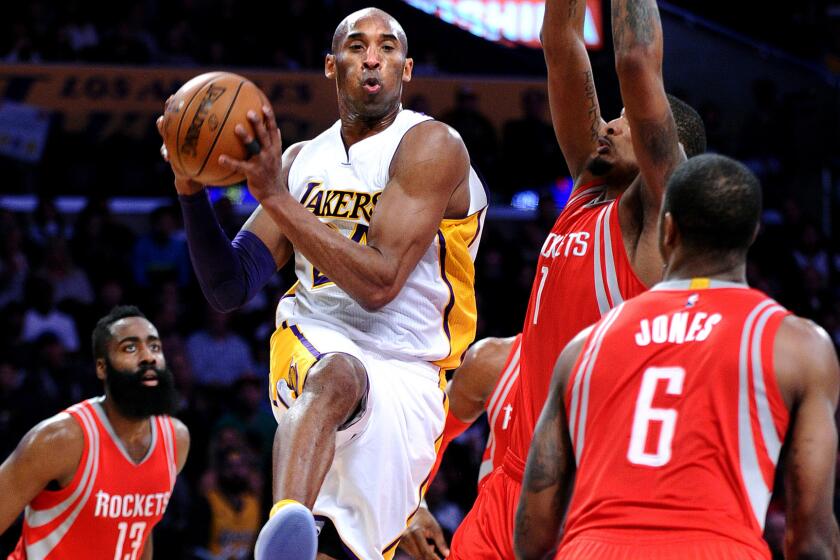 Lakers forward Kobe Bryant looks to pass after driving to the basket against the Rockets during a game Jan. 17.