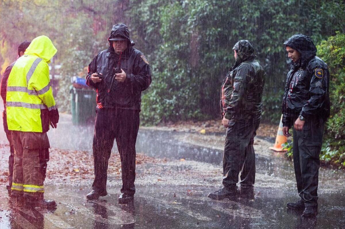 While standing in the pouring rain, Butte County officials coordinate evacuation efforts due to flooding in Chico, Calif.