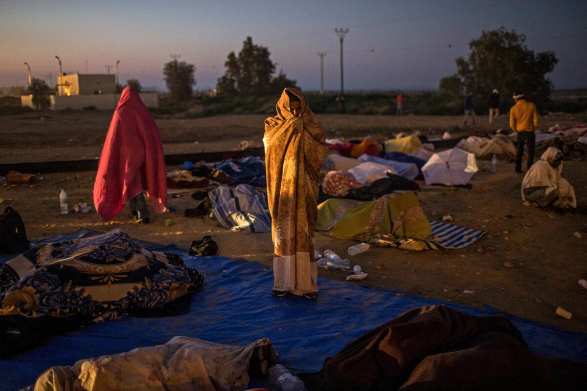 An African asylum seeker covers himself with a blanket as dawn breaks during the second day of protests at the Holot detention center.