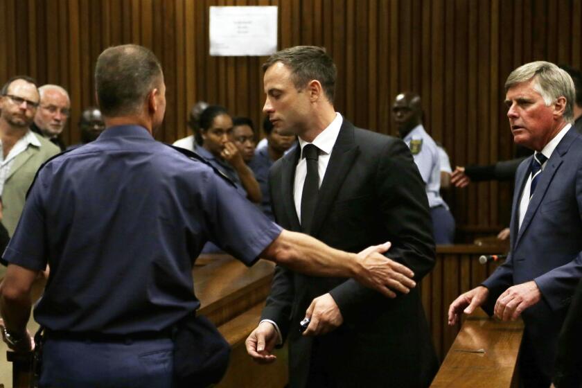 South African sprinter Oscar Pistorius is led from a Pretoria courtroom to a holding cell after being sentenced Oct. 21 in the shooting death of his girlfriend.