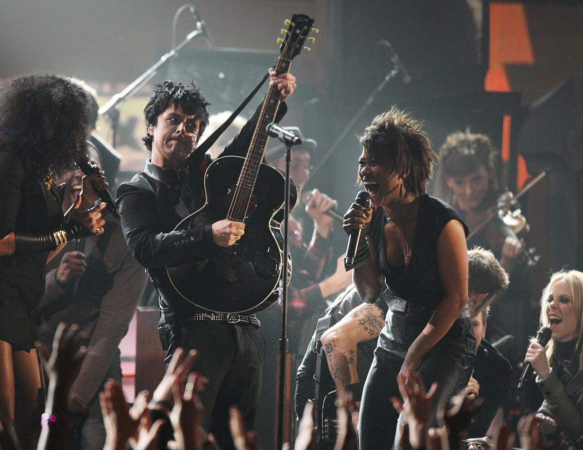 Pop-punk band Green Day, shown performing with the cast of "American Idiot" at the Grammy Awards in 2010, will be inducted into the Rock and Roll Hall of Fame on Saturday in Cleveland.