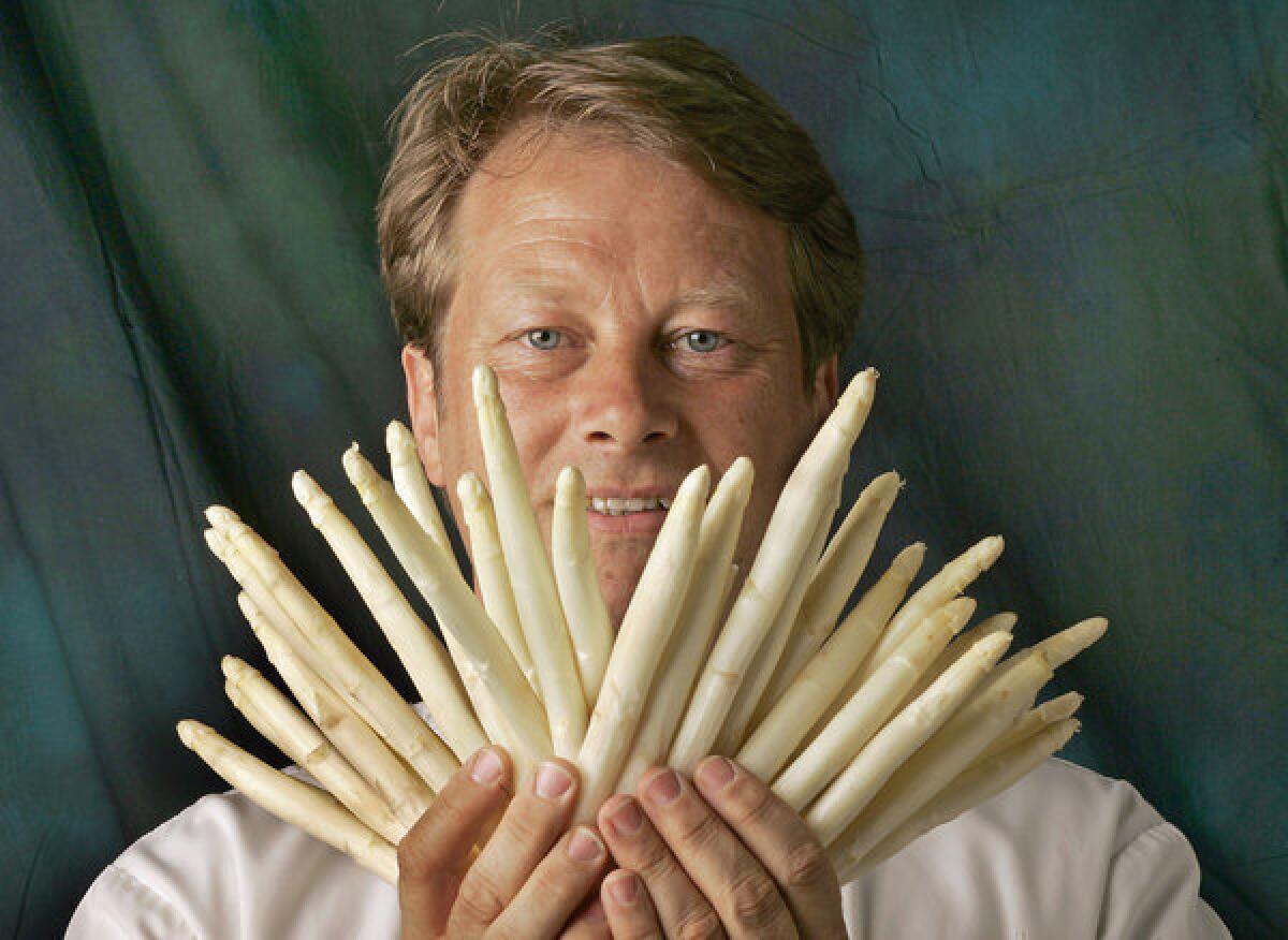 Chef Hans Rockenwagner, pictured in 2005, holds white asparagus, which he has flown in from Europe.