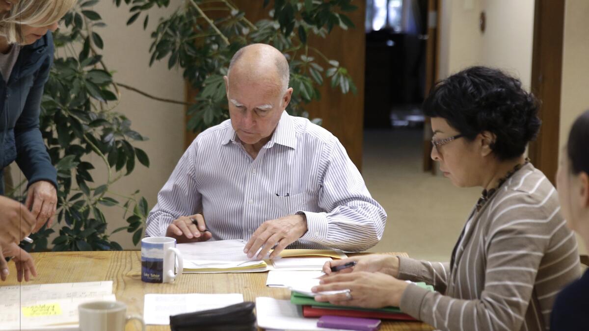 Gov. Jerry Brown, signing bills in his Capitol office on Oct. 9, 2015.