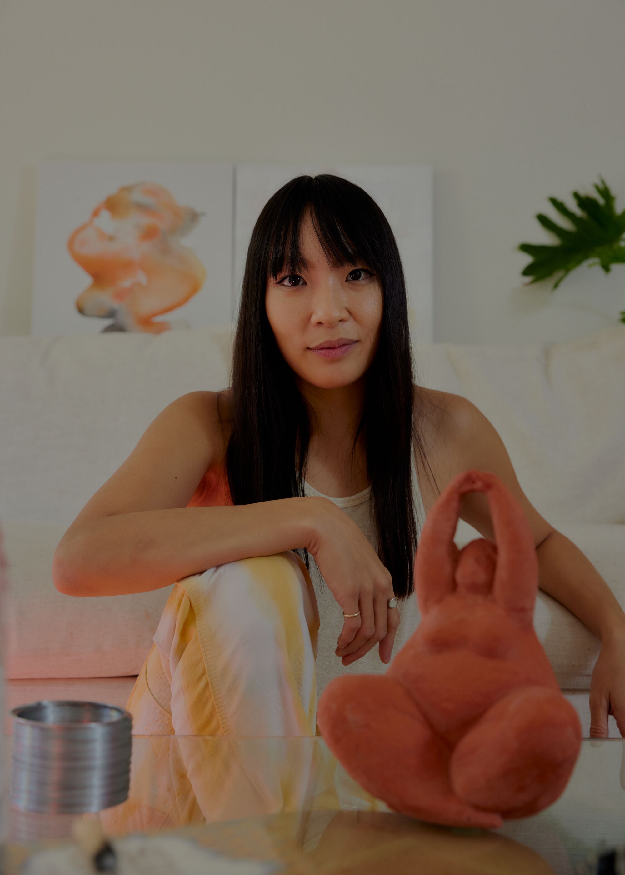 Chef Sandy Ho in her Los Angeles home, surrounded by her painting in the background, an Aphrodite doorstopper
