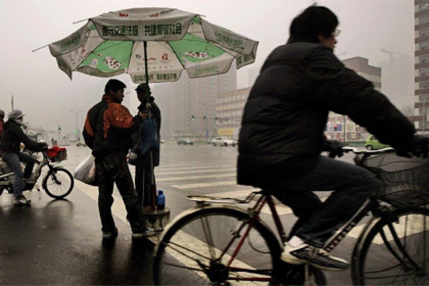 GLOOMY: People ride bikes on a damp day in Beijing last month. The real rainy season comes in summer, and Chinese meteorologists have trained for the Summer Olympics by practicing their rain mitigation techniques at recent special events. Theyve had several successes.
