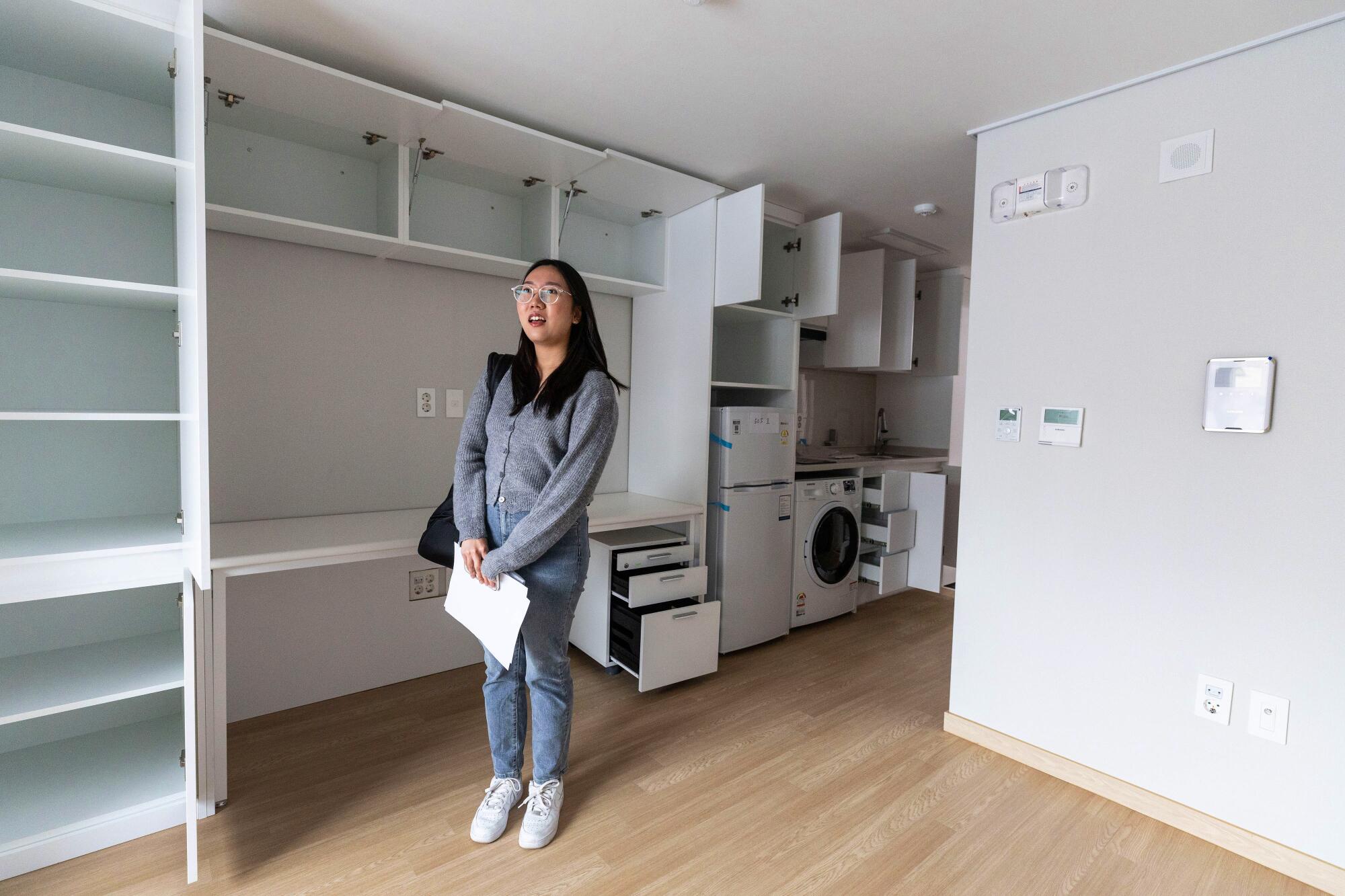Kim Do-yeon stands in a small empty apartment.