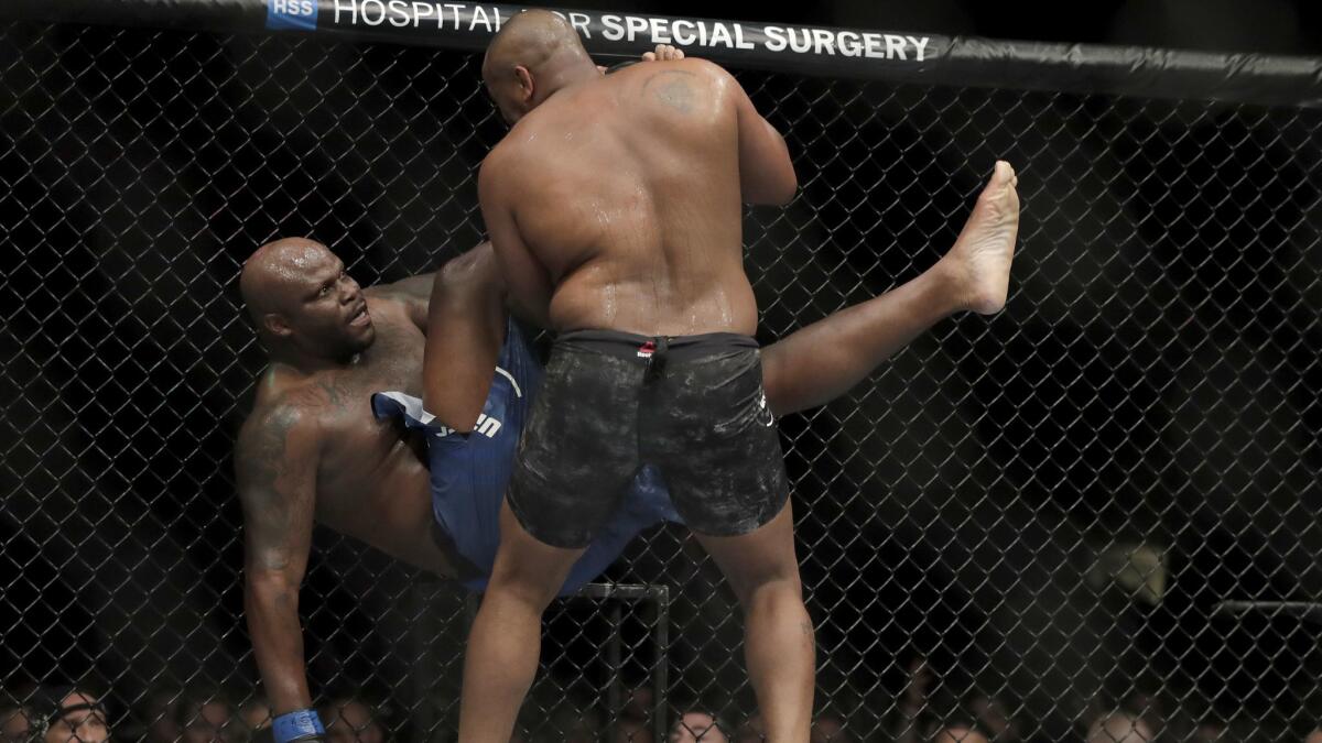 Daniel Cormier, right, drops Derrick Lewis during the second round.