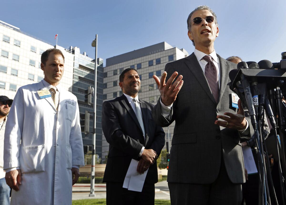 Dr. David Feinberg, right, head of the UCLA Health System, speaks at a news briefing outside Ronald Reagan UCLA Medical Center last week. Feinberg is leaving UCLA to become the CEO of the Geisinger Health System in Pennsylvania.