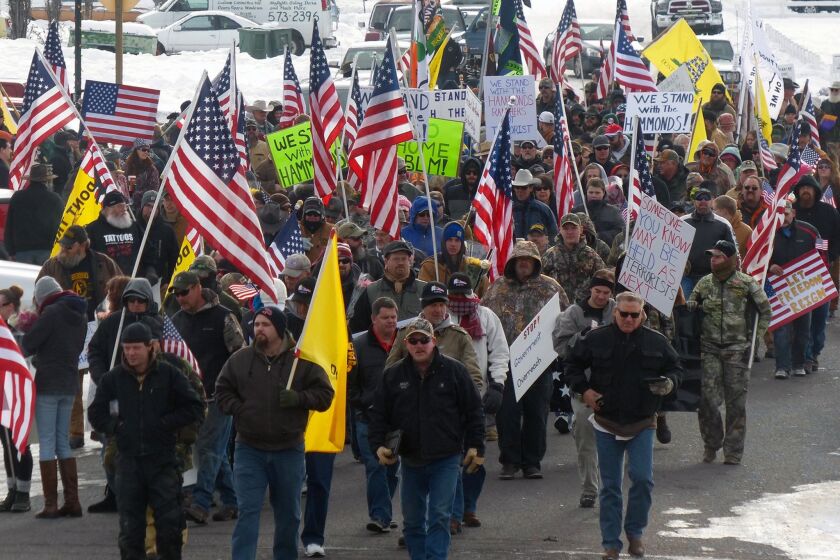 Protesters march on Court Avenue in Burns, Ore., in support of members of a ranching family facing jail time for arson.