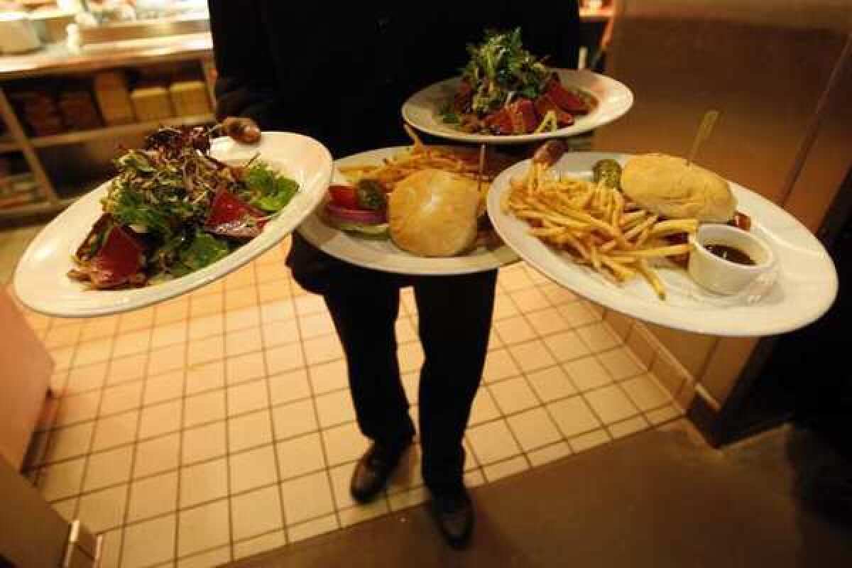 A Los Angeles waiter prepares to deliver lunch. A new report found that such workers often go without sick pay, promotions or healthcare.