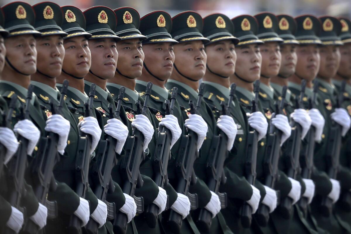 In this Oct. 1, 2019, photo, Chinese People's Liberation Army (PLA) soldiers march in formation during a parade to commemorate the 70th anniversary of the founding of the People's Republic of China in Beijing. China is increasing its defense spending by 6.8% in 2021 as it works to maintain a robust upgrading of the armed forces despite high government debt and the impact of the coronavirus pandemic. (AP Photo/Mark Schiefelbein)
