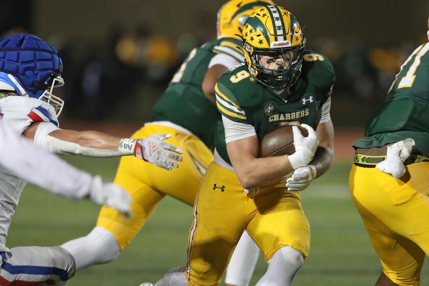 Edison half-back Julius Gillick (9) runs through a gap for touchdown during Alpha League football game against Los Alaamitos at Huntington Beach High on Friday.