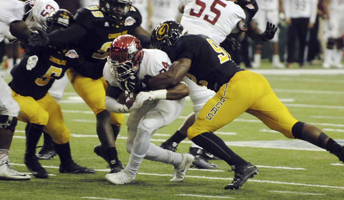 North Carolina Central running back Dorrel McClain is surrounded on the tackle by Grambling State defenders during the first half of the Celebration Bowl on Saturday.