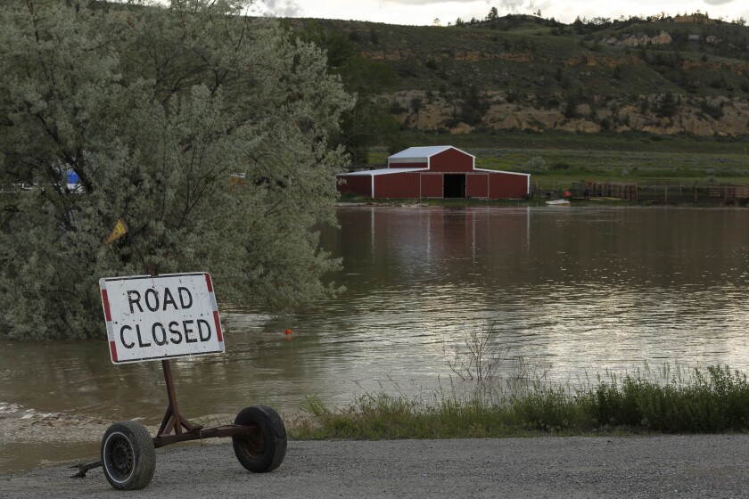 Floodwaters and a "road closed" sign