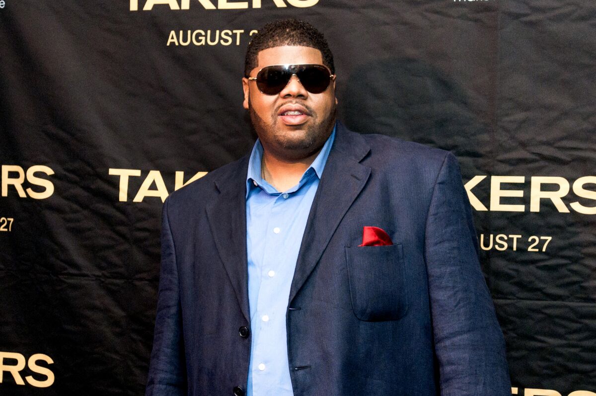 A man in a sport coat and wearing sunglasses