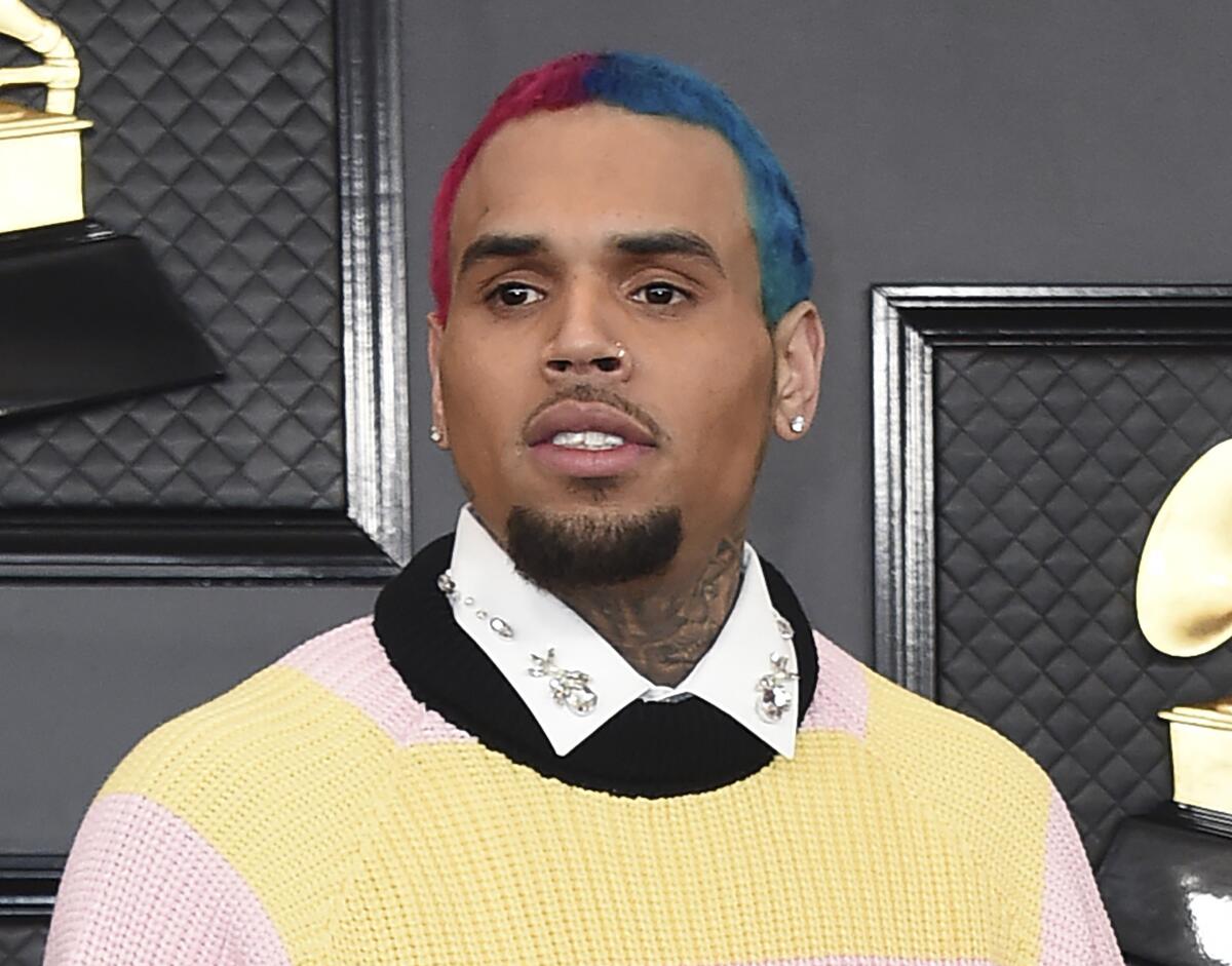 A man with a goatee, mustache and short hair dyed half red and half blue arrives at an awards ceremony