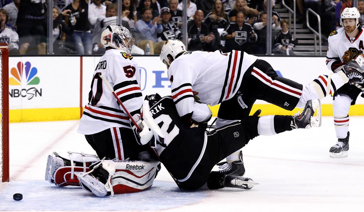Kings forward Marian Gaborik is taken down by Blackhawks defenseman Brent Seabrook after re-directing the puck past goaltender Corey Crawford for a goal in the first period of Game 4 on Monday night at Staples Center.