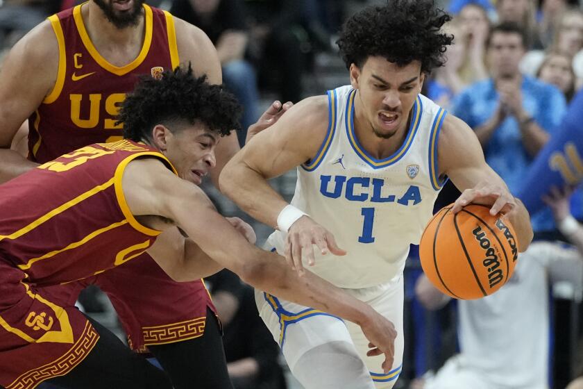 UCLA's Jules Bernard (1) drives up the court against Southern California's Max Agbonkpolo (23) during the first half of an NCAA college basketball game in the semifinal round of the Pac-12 tournament Friday, March 11, 2022, in Las Vegas. (AP Photo/John Locher)