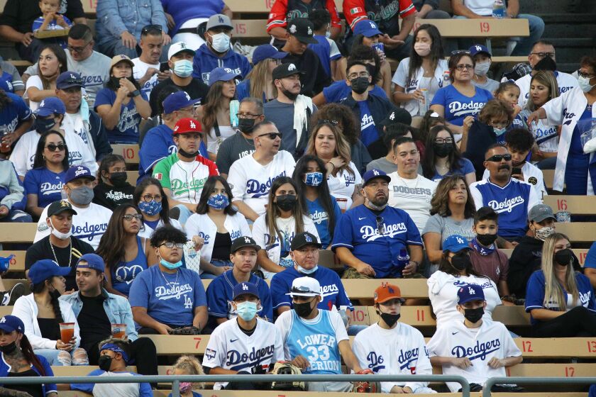 LOS ANGELES, CA - AUGUST 20, 2021: Most fans in the bleacher seats are wearing masks as tonight is the beginning of a new LA County health mandate requiring venues with more than 10,000 people to require masks at Dodger Stadium on August 20, 2021 in Los Angeles, California.(Gina Ferazzi / Los Angeles Times)