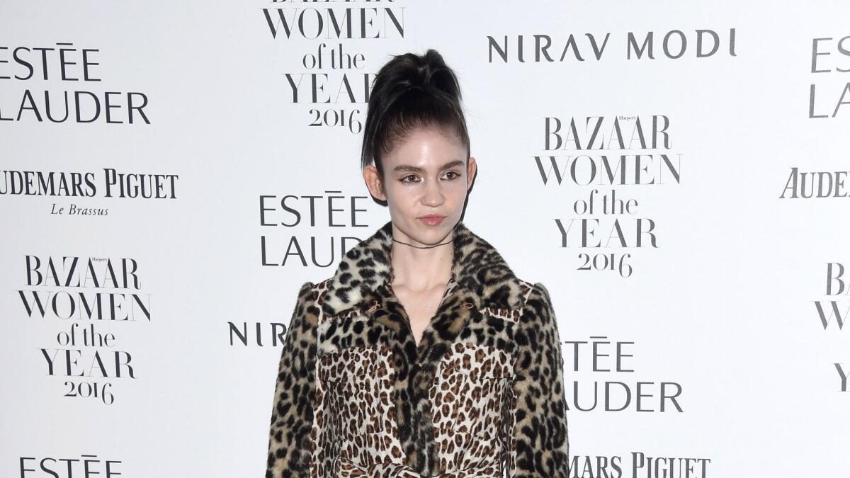 Grimes wears a leopard-print coat.