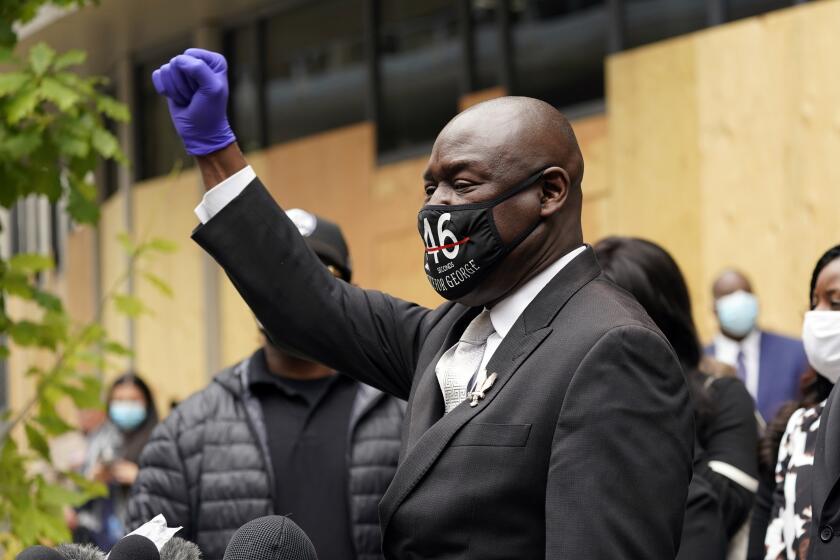 Attorney Ben Crump, representing George Floyd's family, raises a closed fist as he addresses the media after a hearing at the Hennepin County Family Justice Center, Friday, Sept. 11, 2020 in Minneapolis for four former Minneapolis Police officers who are charged in the death of Floyd on Memorial Day in Minneapolis. (AP Photo/Jim Mone)
