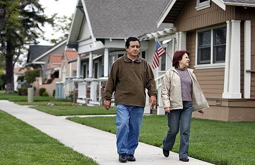 Jacienta Lobaton and Jose Melendez, both residents of Anaheim for two years, take a walk along Lemon Street. Anaheim is moving toward a future as a middle-class Latino city, much like Whittier or Downey. More than half of the Latinos in Anaheim were born in the U.S. and own homes.