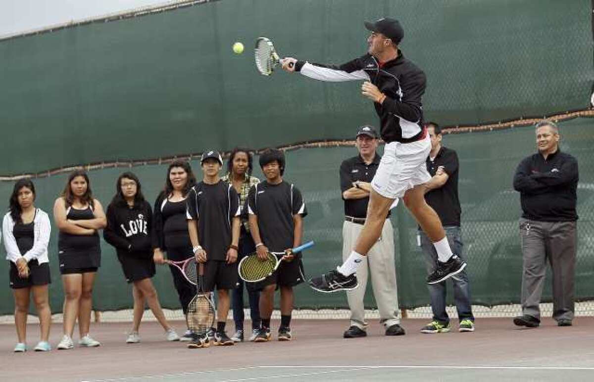 Orange County Breakers tennis player Steve Johnson returns a ball to a student player during a visit to his former high school, Orange, for a tennis clinic on Monday.