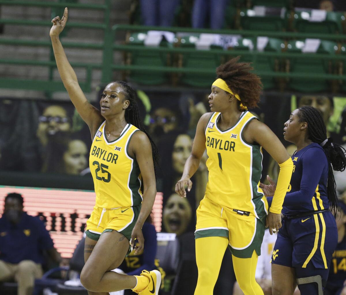 Baylor center Queen Egbo, left, celebrates her score over West Virginia with teammate NaLyssa Smith in the first half of an NCAA college basketball game, Monday, March 8, 2021, in Waco, Texas. (Rod Aydelotte/Waco Tribune Herald, via AP)