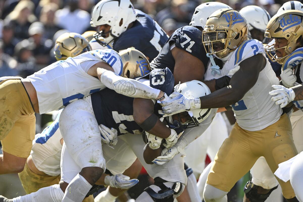 UCLA defenders try to bring down Penn State's running back