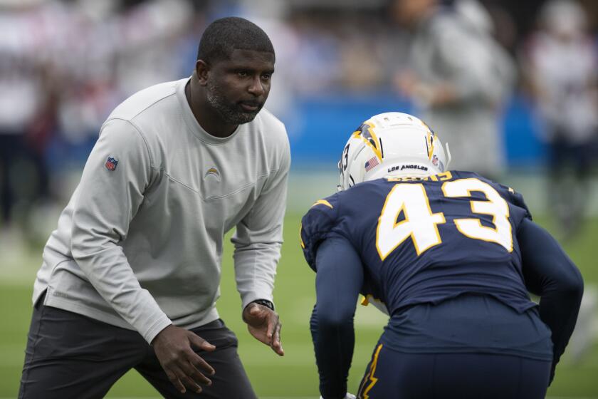 Los Angeles Chargers secondary coach Derrick Ansley works with cornerback Michael Davis (43).