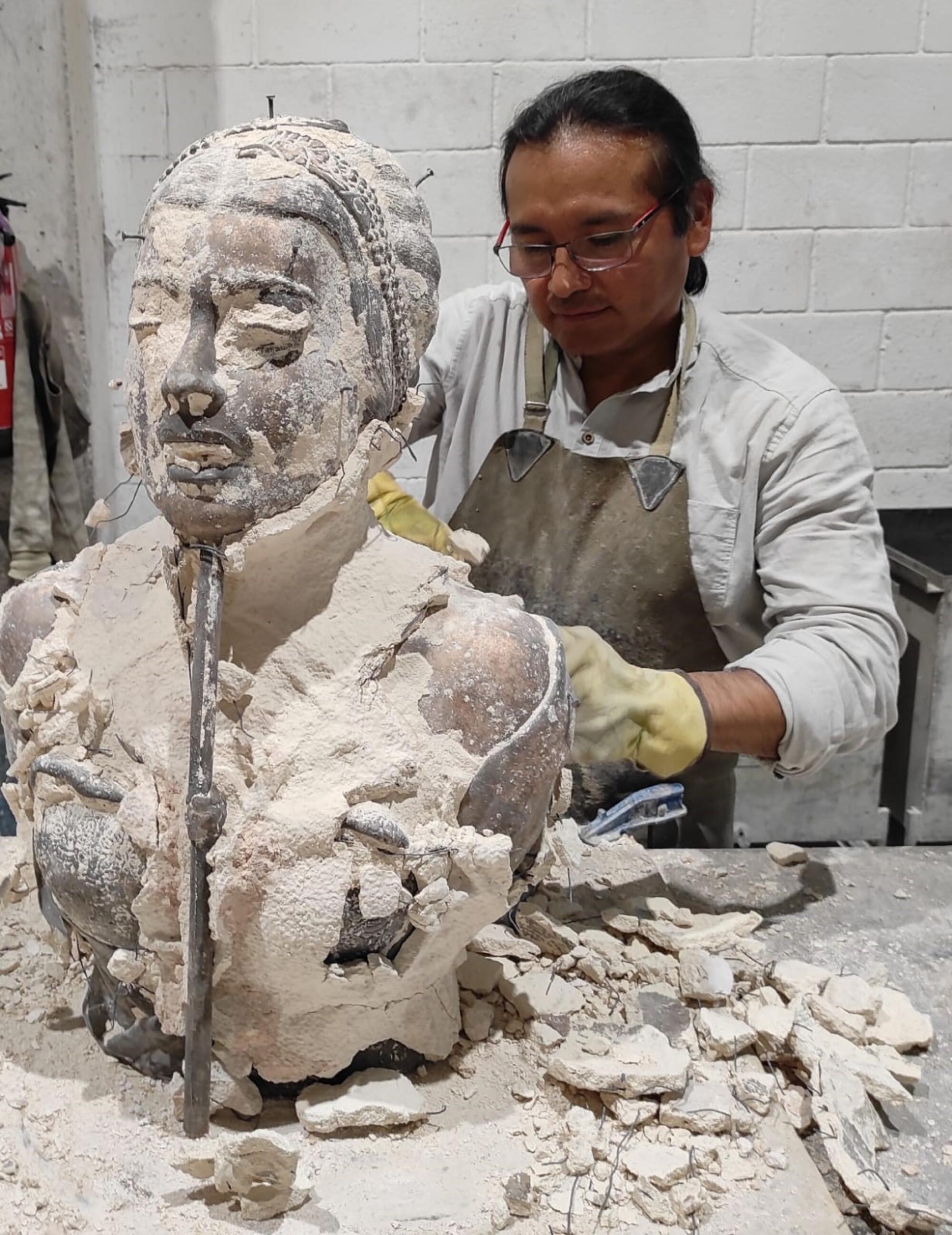 Martín Espinoza Grajeda works on a bronze bust.