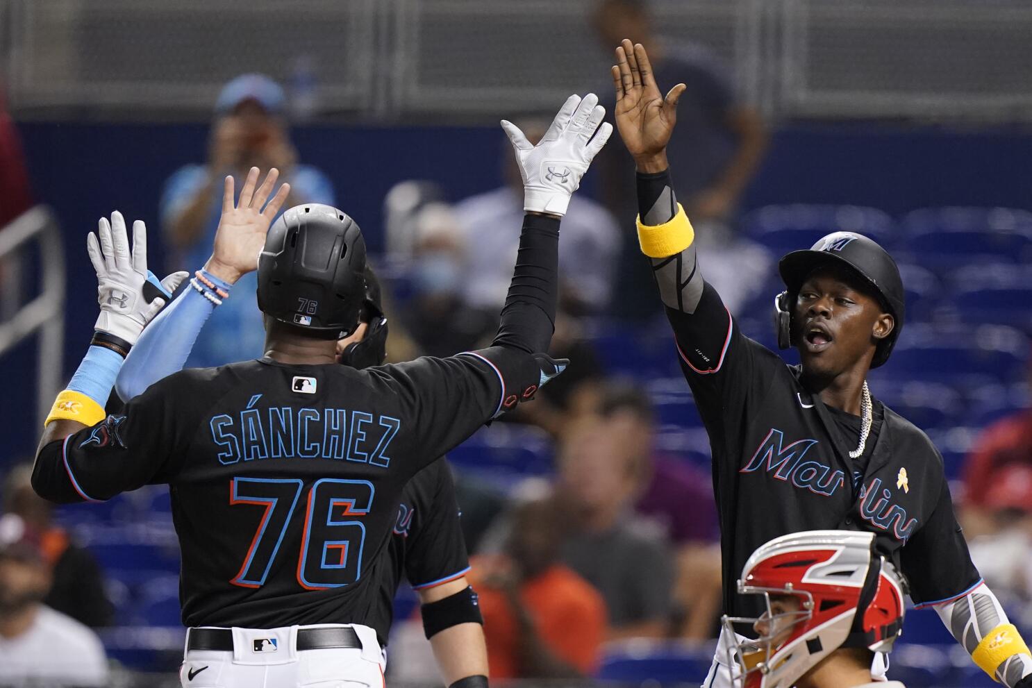 Miami Marlins' Jesus Sanchez, left, is congratulated by first base