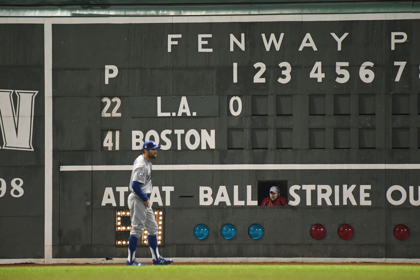 With a Fenway Park scoreboard handler looking on, Dodgers Chris Taylor gets into position in the first inning.