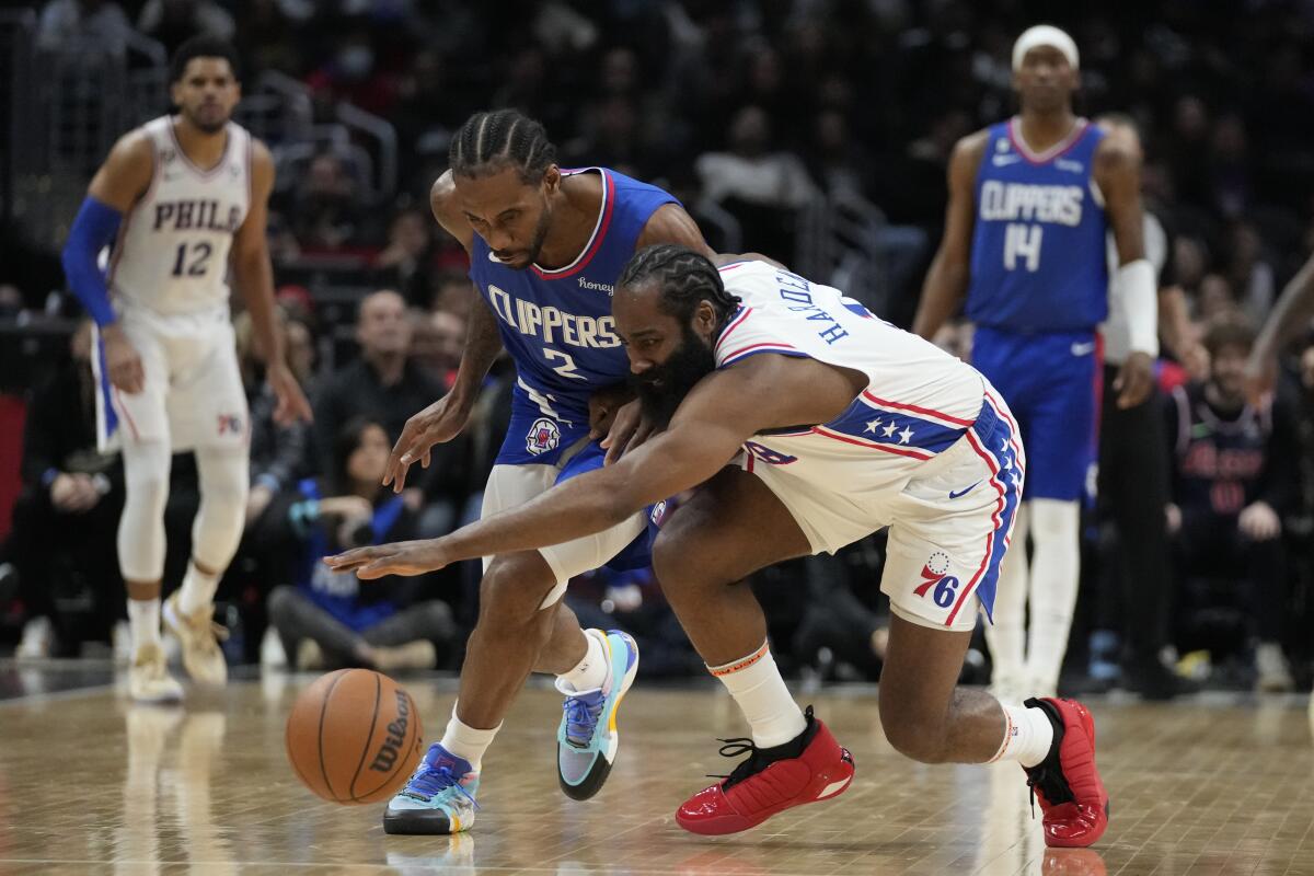 Clippers forward Kawhi Leonard, left, and 76ers guard James Harden chase after a loose ball during a game last season.