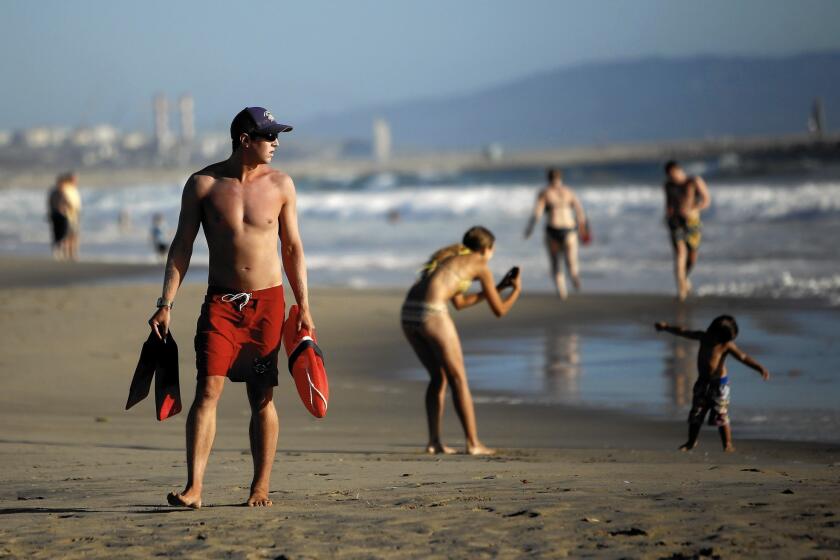 L.A. County lifeguard Morgan Wallace watches the water next to the pier in Venice. During the peak of a heat wave in September, lifeguards made 187 rescues in a single day -- 88 of them at Venice Beach alone.