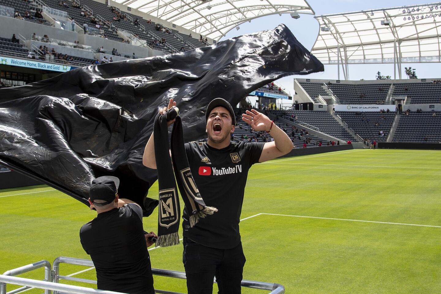 David Cordero of Victorville leads a rally group called the Empire Boys while watching an LAFC soccer game on giant video screens inside the new Banc of California Stadium on April 21.