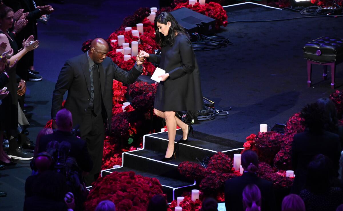 Michael Jordan helps Vanessa Bryant off the stage at the memorial at Staples Center.