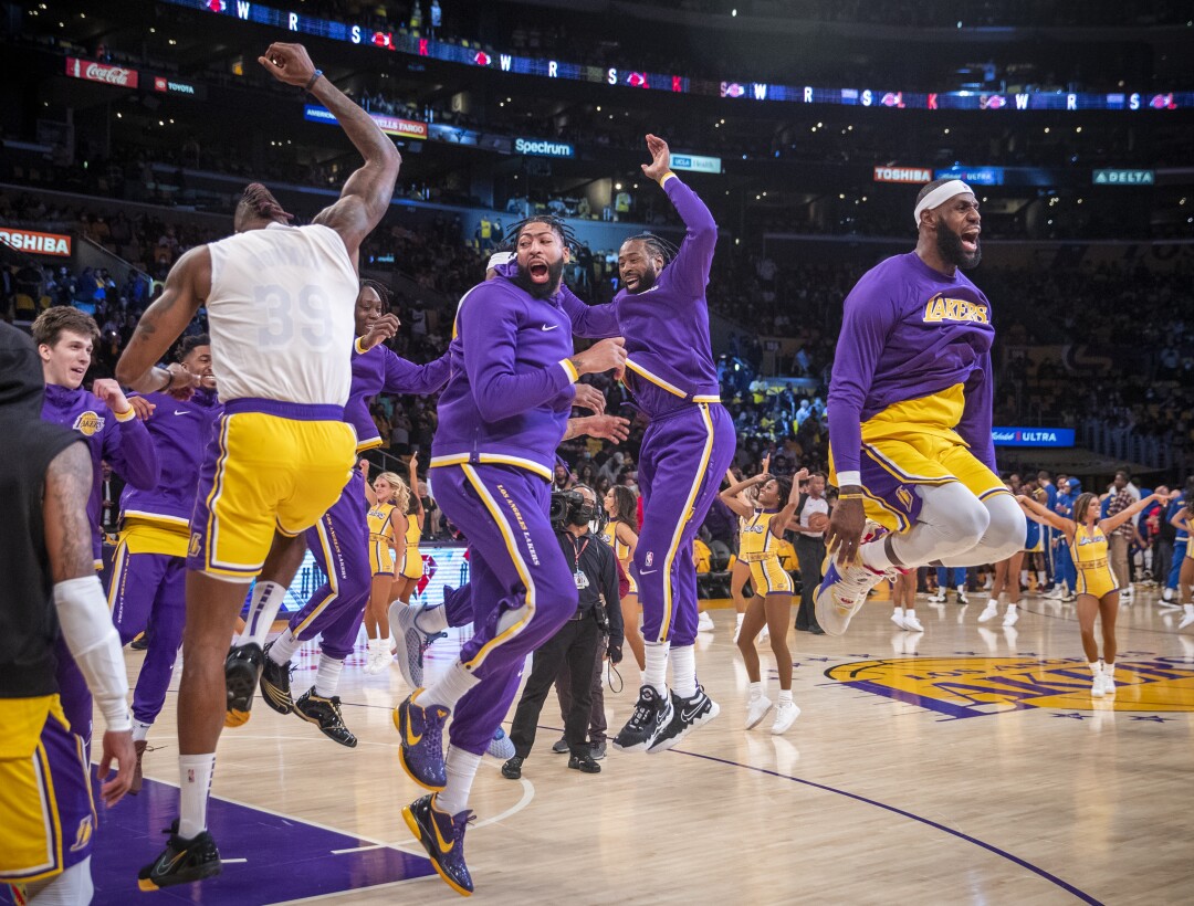 Lakers players jump in the air on the court