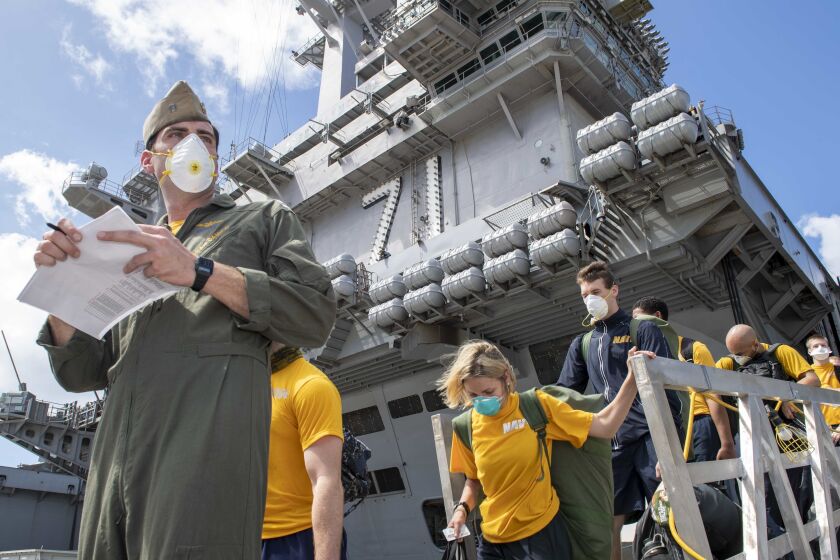 U.S. Sailors assigned to the aircraft carrier USS Theodore Roosevelt (CVN 71) depart the ship to move to off-ship berthing April 10. (U.S. Navy photo by Mass Communication Specialist 1st Class Chris Liaghat)
