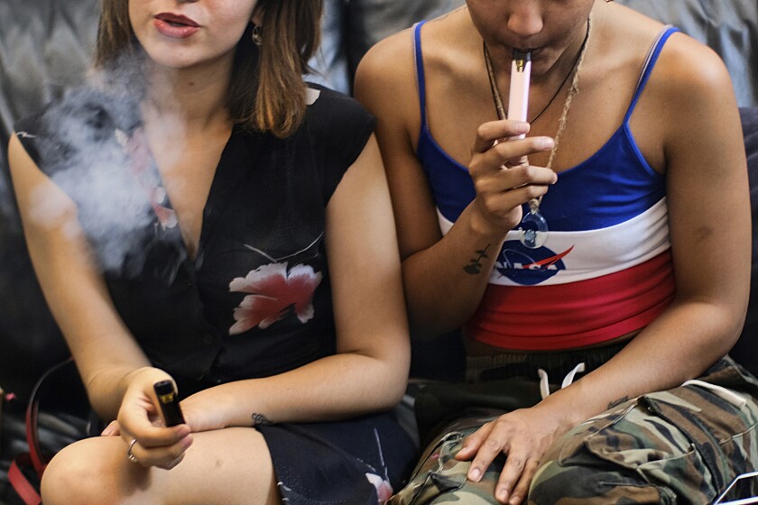 In this Saturday, June 8, 2019 file photo, two women use vape pens at a party in Los Angeles.
