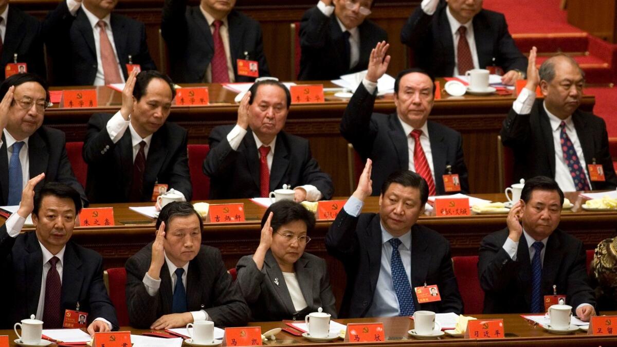 China's top leadership, including rising stars such as then-Shanghai party chief Xi Jinping, second from right on bottom row, raise their hands to approve resolutions passed during the closing ceremony for the 17th Communist Party congress in Beijing in 2007.