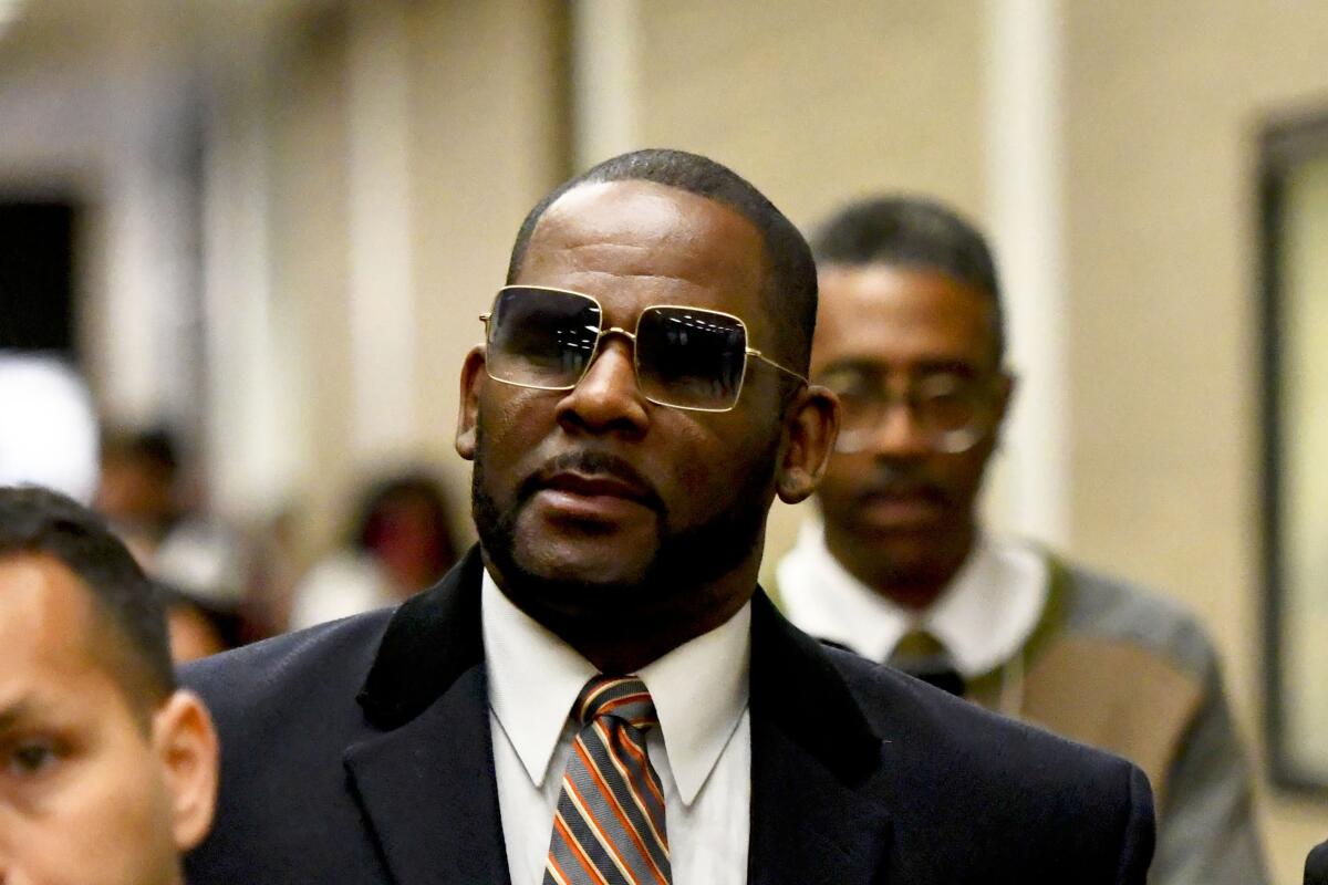 FILE - Musician R. Kelly, center, leaves the Daley Center after a hearing in his child support case on May 8, 2019, in Chicago. Closing arguments are scheduled Monday, Sept. 12, 2022 for R. Kelly and two co-defendants in the R&B singer’s trial on federal charges of trial-fixing, child pornography and enticing minors for sex, with jury deliberations to follow. (AP Photo/Matt Marton, File)