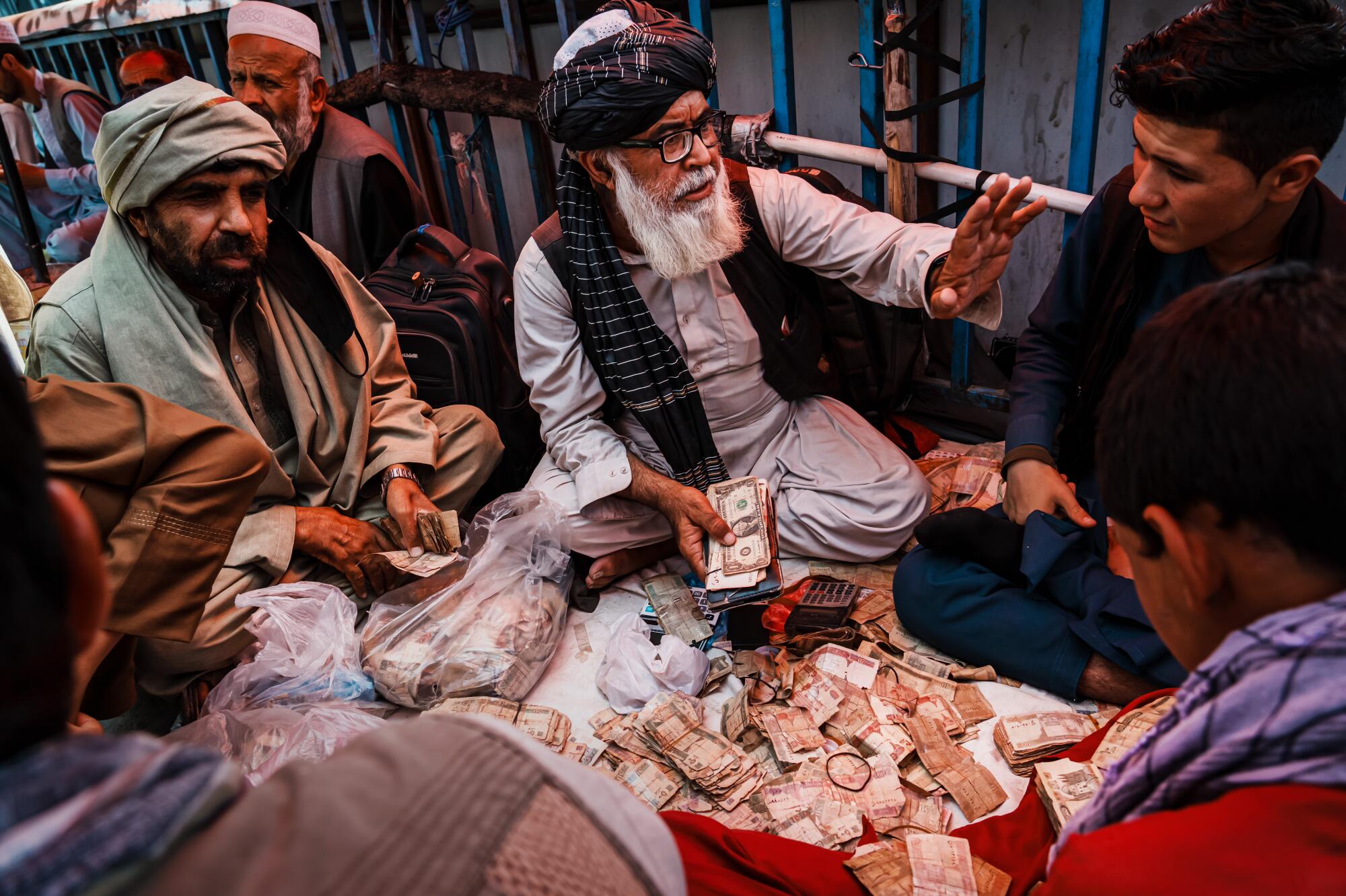 Currency traders sorting through piles of Afghan currency 