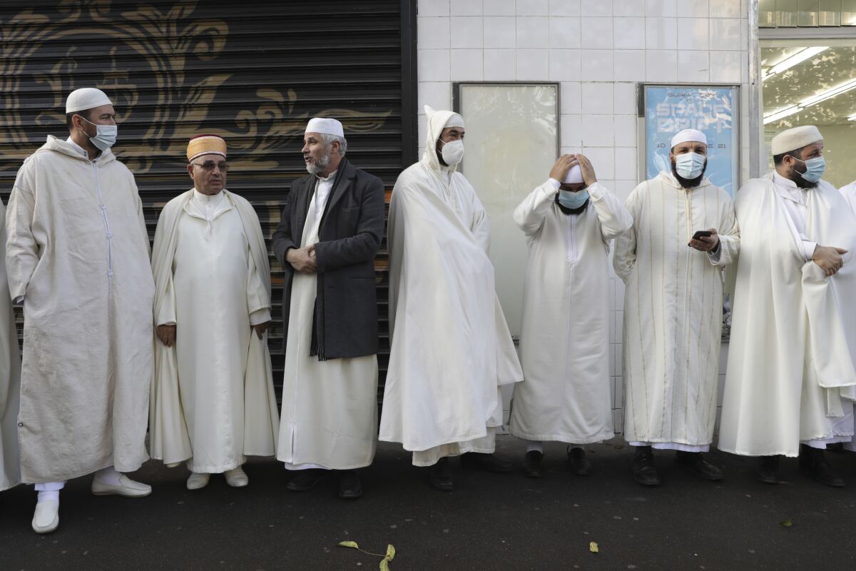 FILE - Imams from the Paris Mosque gather before paying their homage to the victims of the Nov. 13, 2015 attacks, near the Bataclan concert hall in Paris, Friday, Nov.12, 2021. The French government on Saturday, Feb. 5, 2022, forged ahead with efforts to reshape Islam in France and rid it of extremism, introducing a new body made up of clergy and laymen — and women — to help lead the largest Muslim community in western Europe. (AP Photo/Adrienne Surprenant, File)