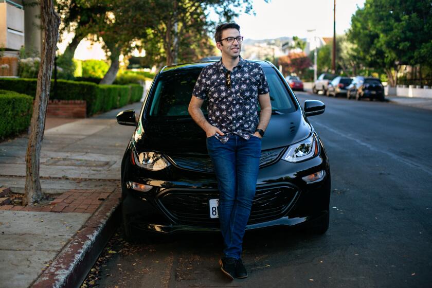 ENCINO, CA - JULY 21: Sam Dudley of Encino poses for a portrait with his Chevy Bolt electric car on Wednesday, July 21, 2021 in Encino, CA.(Jason Armond / Los Angeles Times)