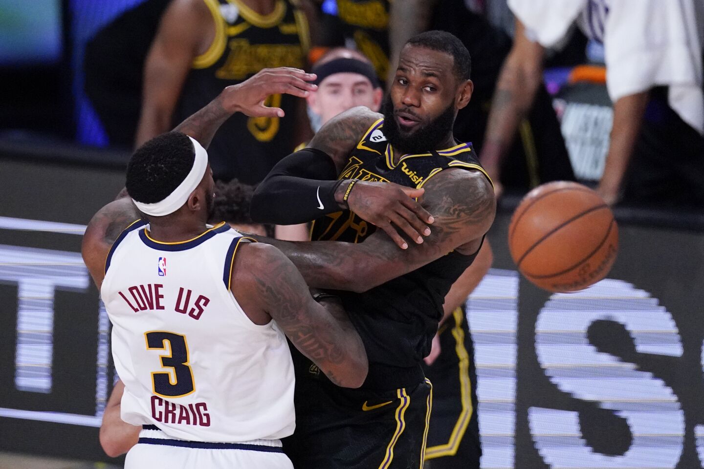 Lakers forward LeBron James whips a pass to a teammate while defended by Nuggets forward Torrey Craig during Game 2.